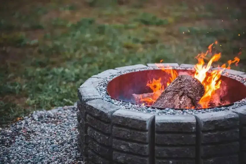 Round stone fire pit on a gravel pad