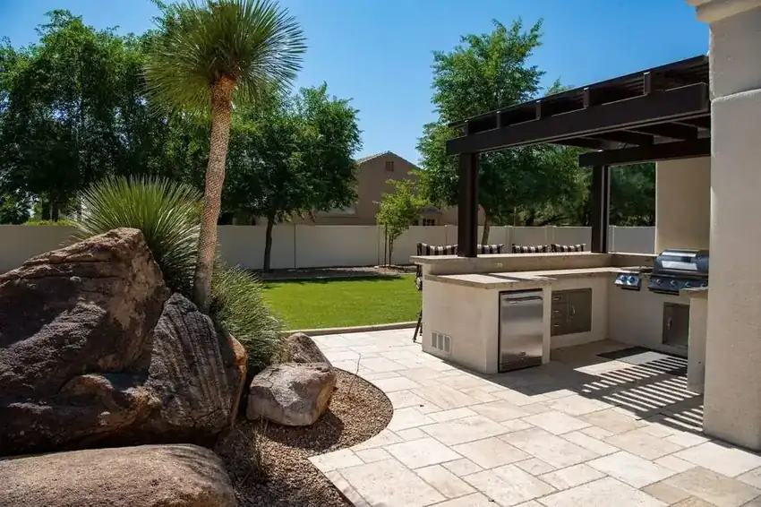 Paver patio with an outdoor kitchen and pergola